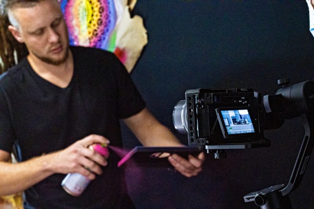 Gustavo Gomes pinta com spray enquanto é filmado no estúdio