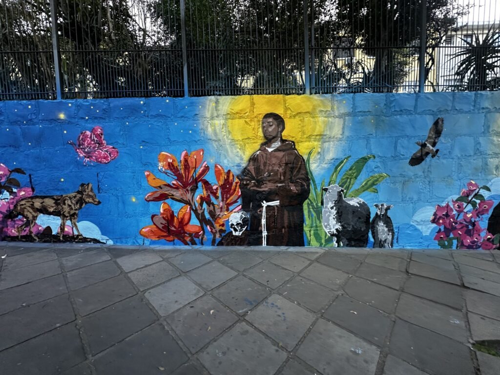 O muro do Museu dos Capuchinhos pintado com São Francisco, flores vermelhas, bichos e o céu estrelado