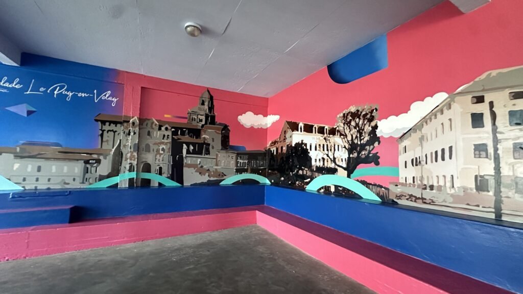 Sala com o prédio histórico do colégio pintado em preto e branco sobre fundo rosa
