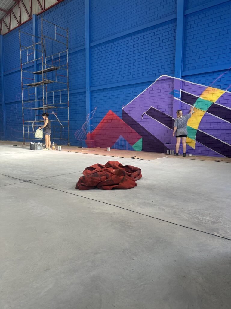 A parede do ginásio no começo da pintura, com o andaime montado