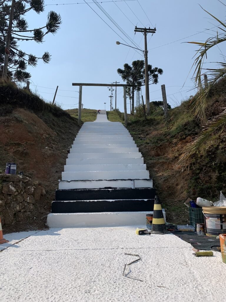 Os primeiros degraus já pintados, com cones e latas na calçada