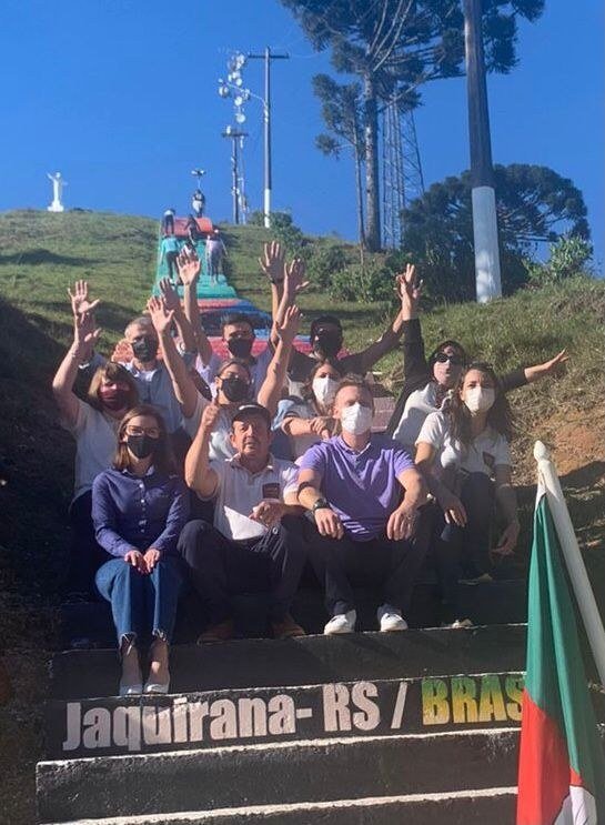 Grupo comemorando sentado nos degraus pintados, no dia da entrega