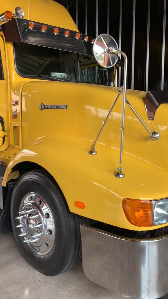 Frente de um caminhão amarelo de verdade parado no galpão