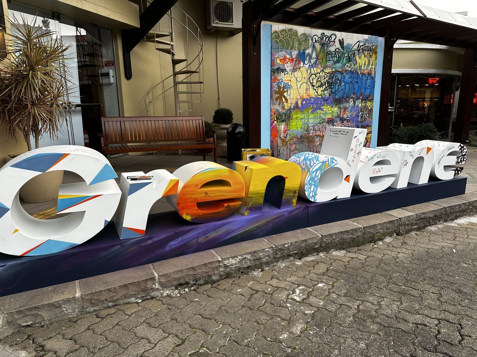 Letreiro da Grendene em letras de volume, com as faces pintadas em cores e padrões