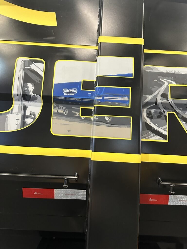 Detalhe das letras com caminhões e estrada pintados dentro