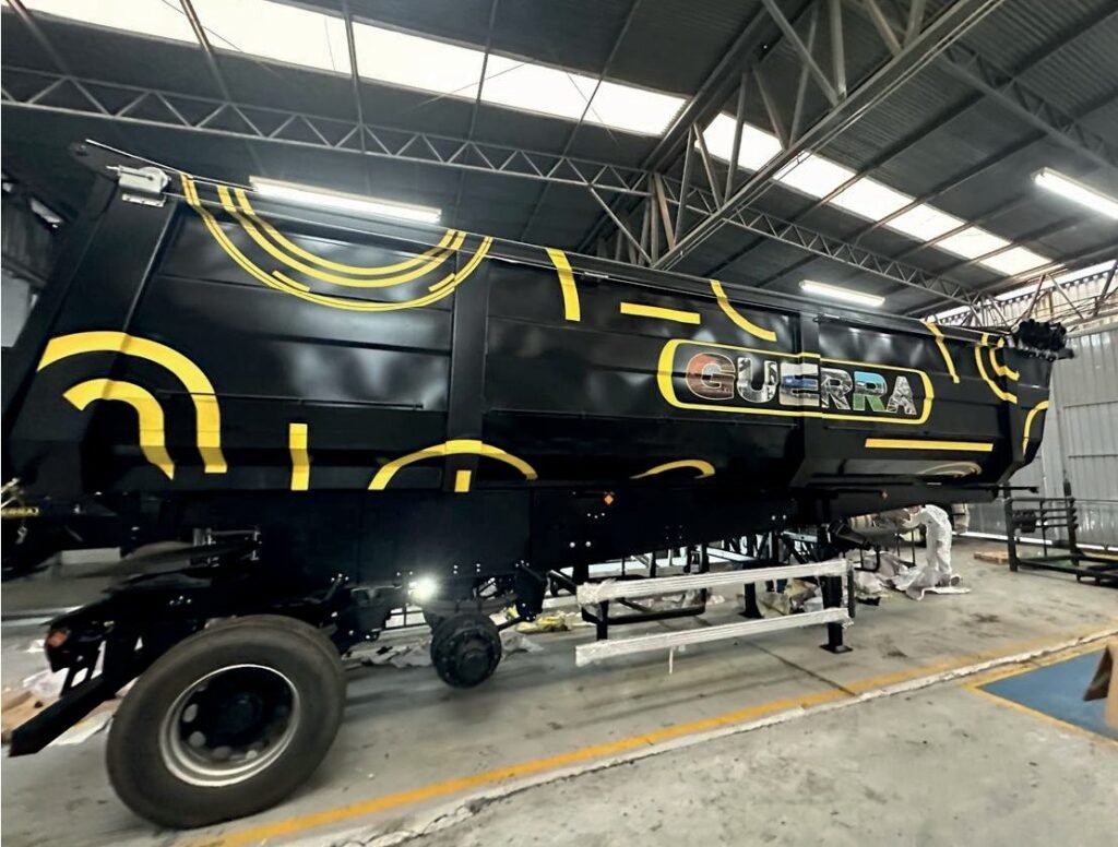 Implemento rodoviário da Guerra dentro do galpão, pintado de preto com grafismos amarelos