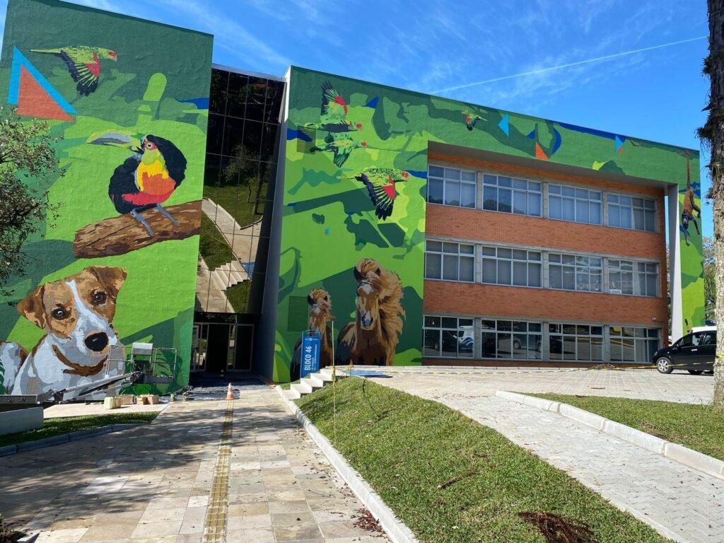 Fachada do hospital veterinário com o tucano, o cachorro e outros bichos sobre fundo verde