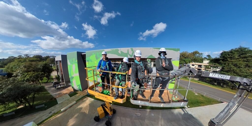 A equipe na plataforma elevatória, com o campus ao fundo