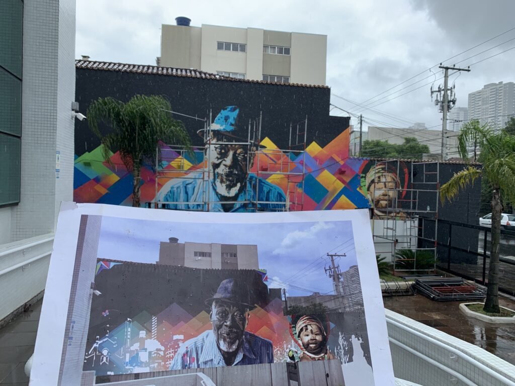 O esboço impresso seguro na frente do mural, mostrando o desenho que virou parede