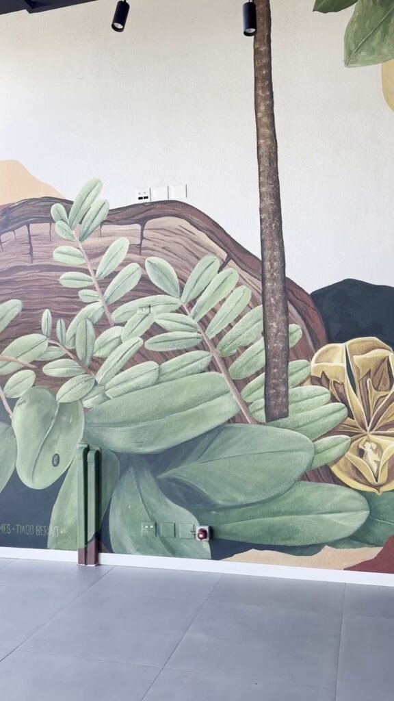 Folhas verdes e flores amarelas em volta de um tronco pintado