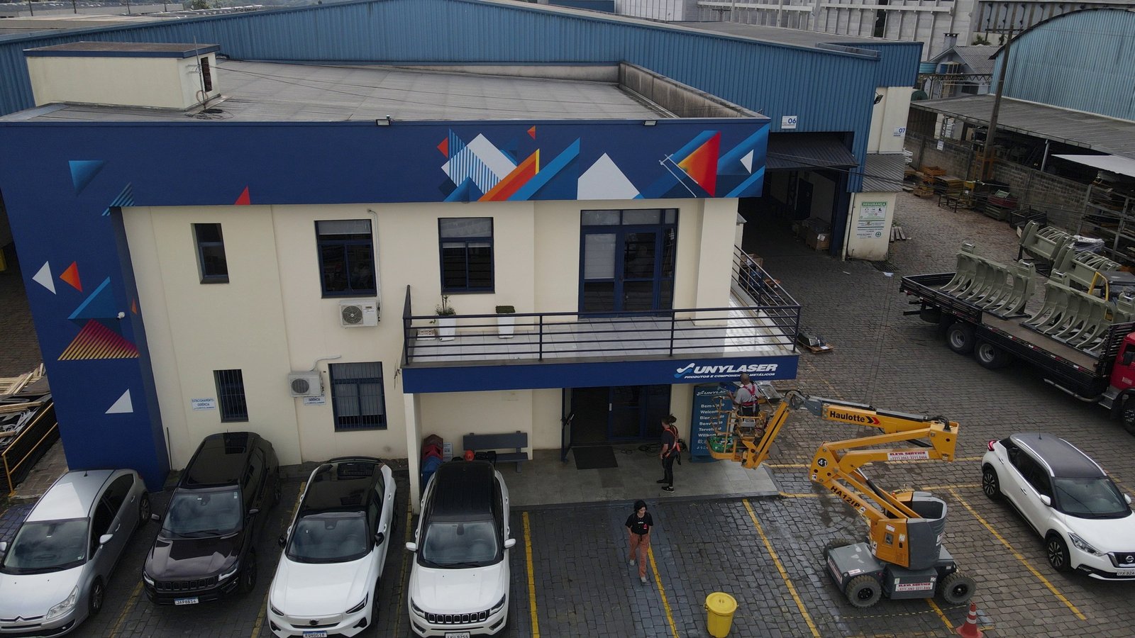Fachada do escritório da Unylaser, do grupo PCP Steel, com o padrão de triângulos do selo de 45 anos, vista de drone