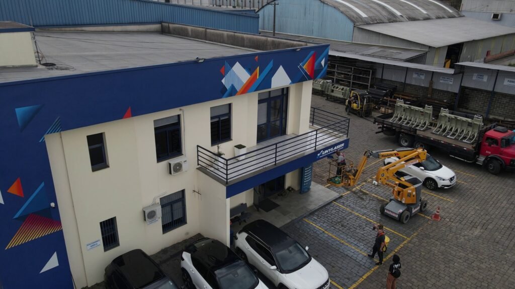 A lateral azul do escritório com triângulos laranja, azuis e brancos, vista de drone