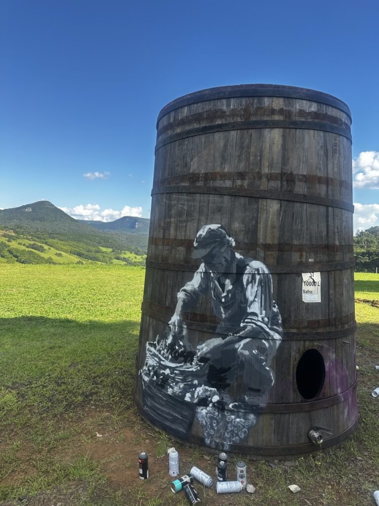 Outra pipa pintada com um trabalhador em preto e branco, com as montanhas ao fundo