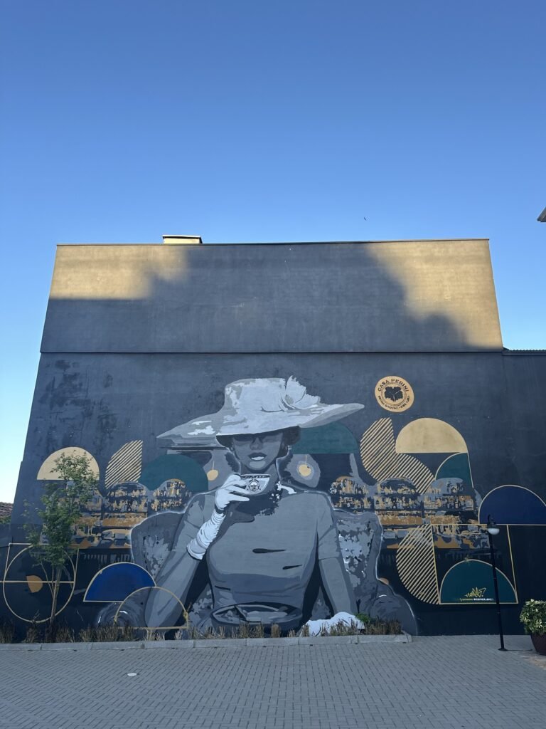 Fachada escura com o retrato de uma mulher de chapéu e formas circulares