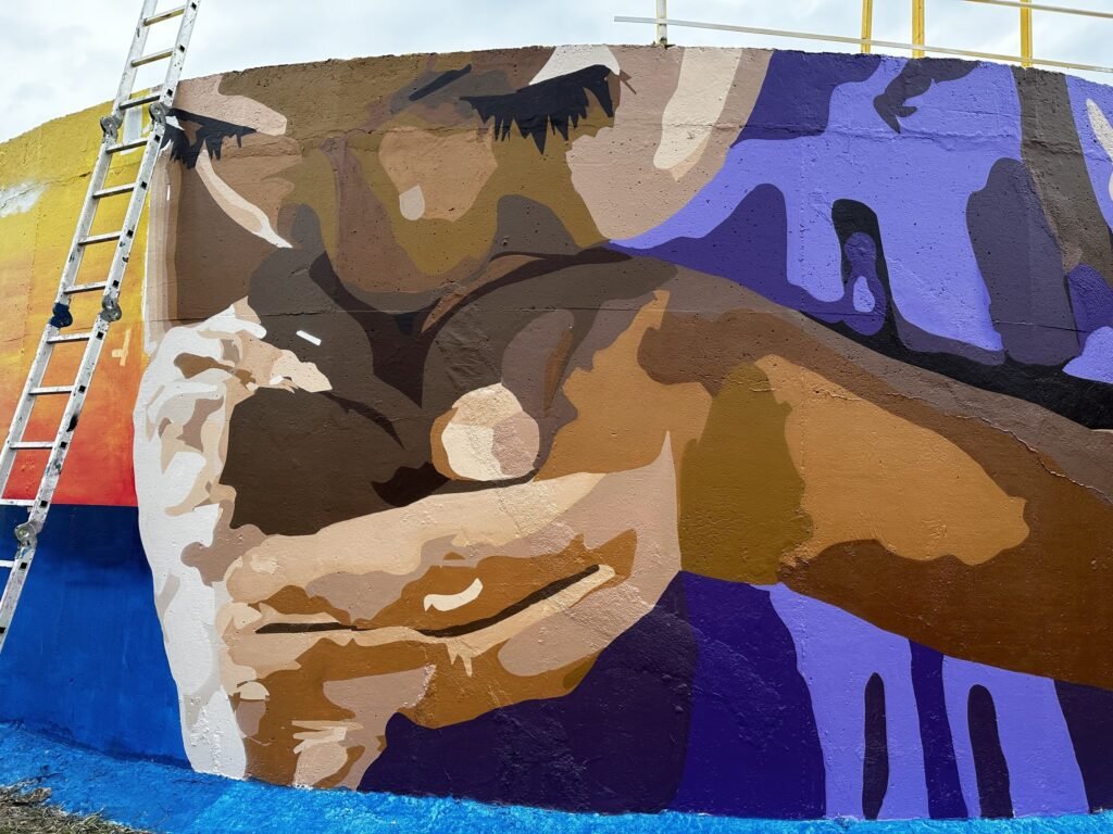 Detalhe das mãos pintadas no reservatório, com a escada encostada