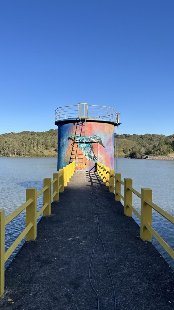 A torre pintada no meio da Represa Maestra, no fim da passarela amarela