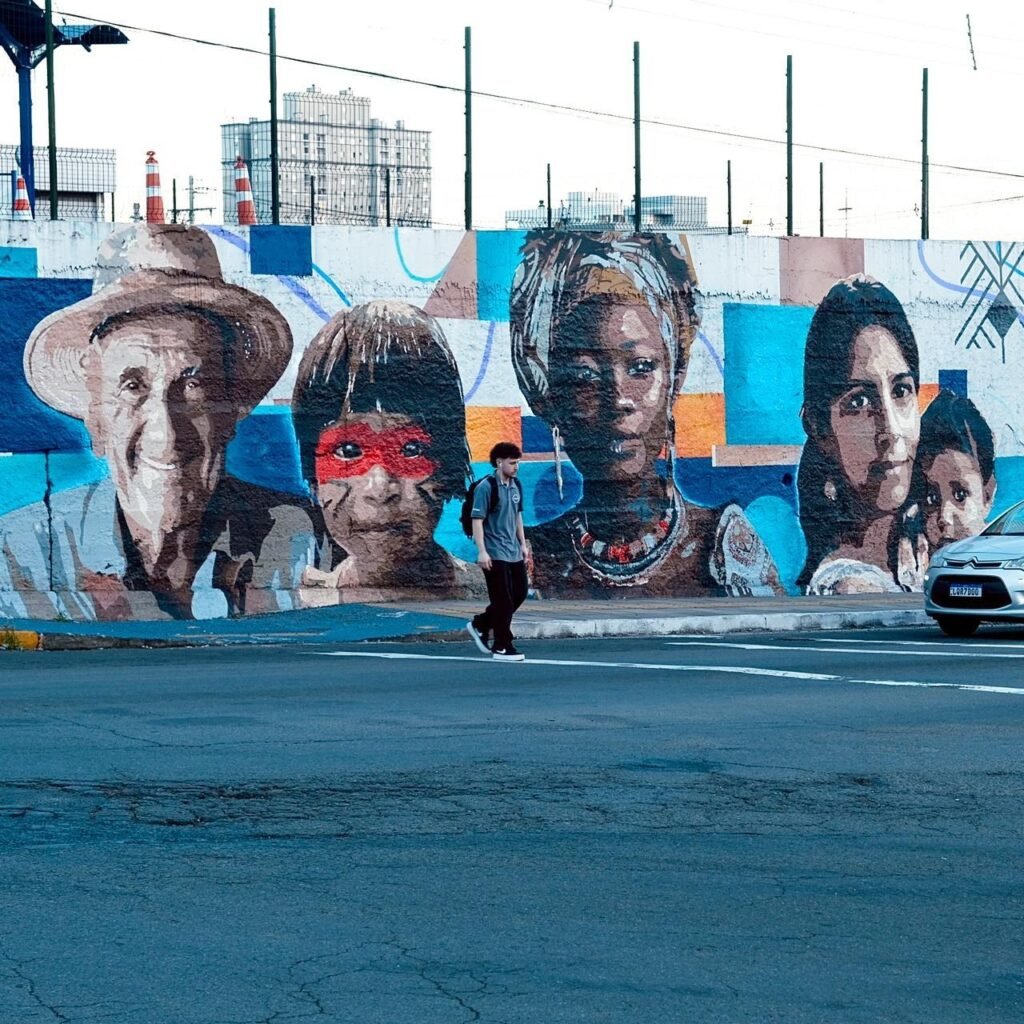 O mural da 11ª Aldeia SESC inteiro, com os retratos lado a lado na parede da rua