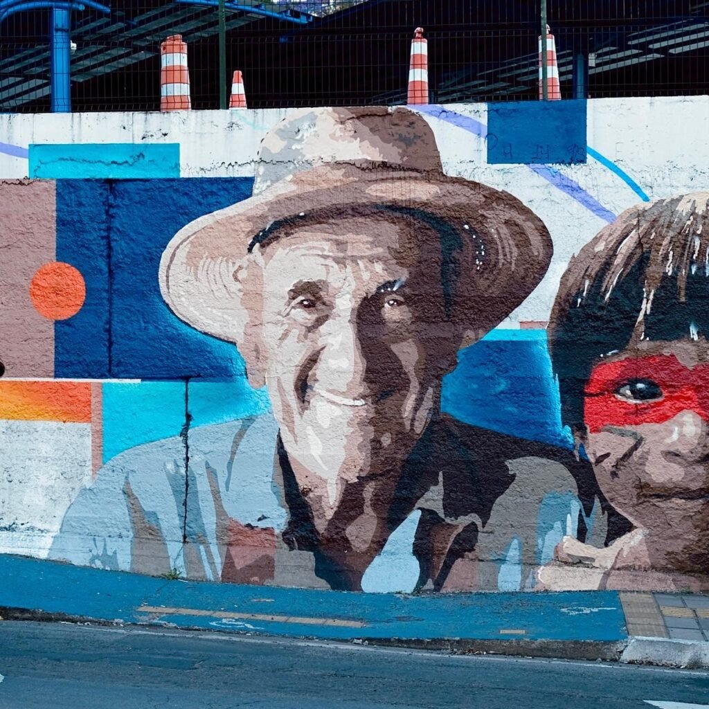 Retrato de um homem idoso de chapéu ao lado da criança com pintura facial