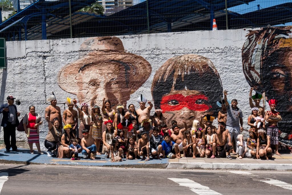 Um grupo reunido em frente ao mural, na calçada